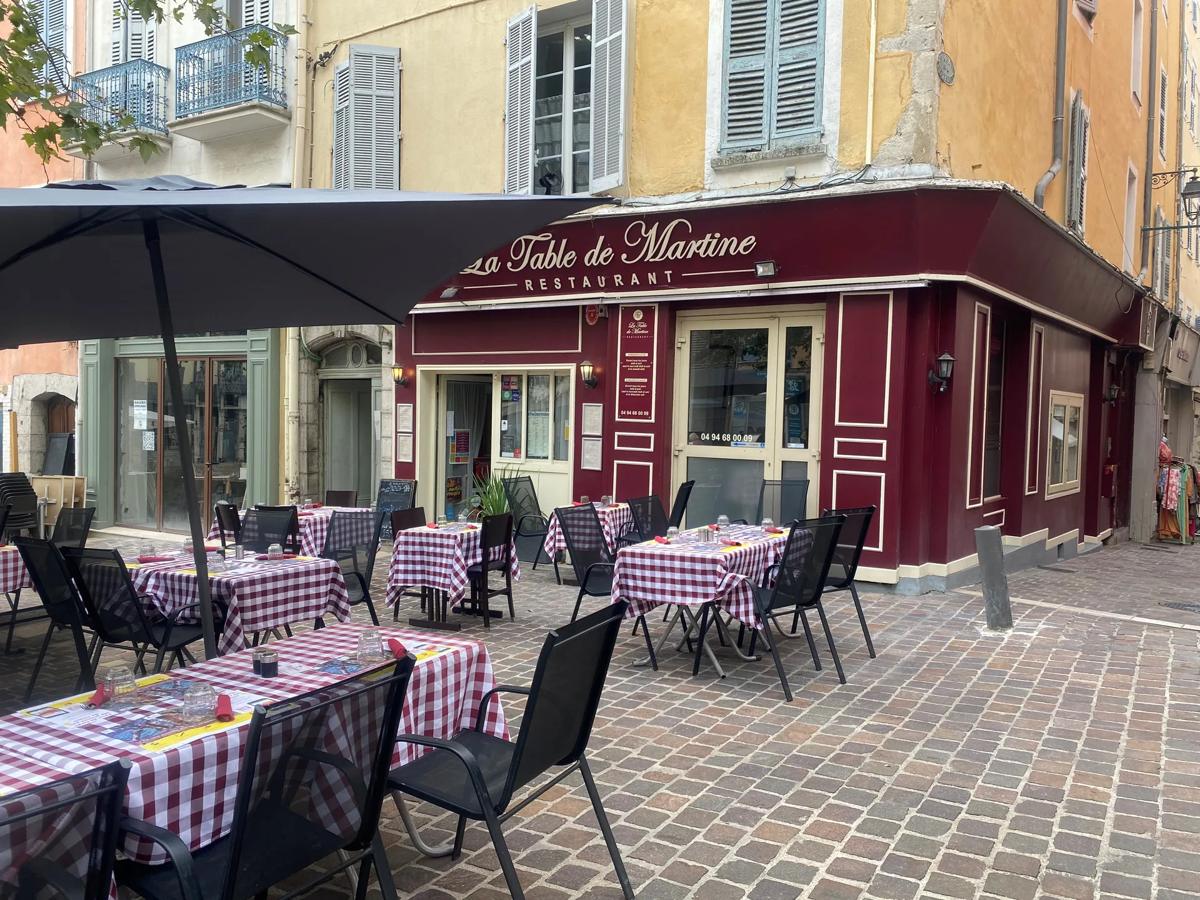 Terrasse du restaurant sur la place du Marché, tables aux nappes à carreaux